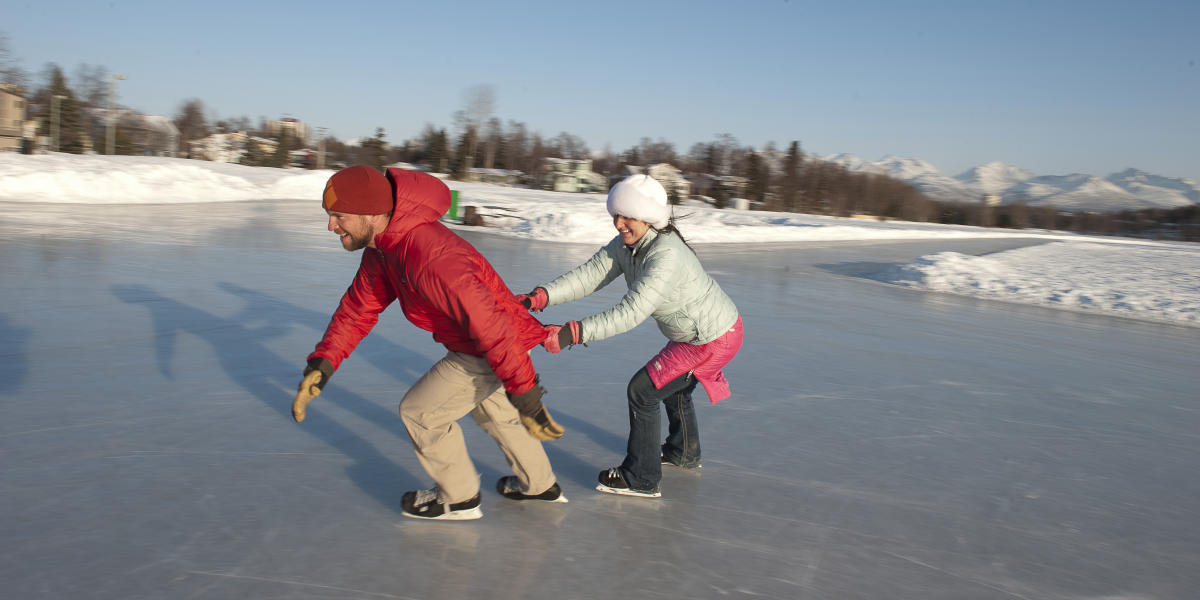 Couple ice skating outdoors in Anchorage.