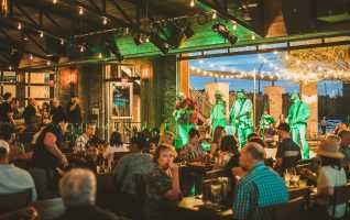People at a restaurant with open patio concert at Texas Live!