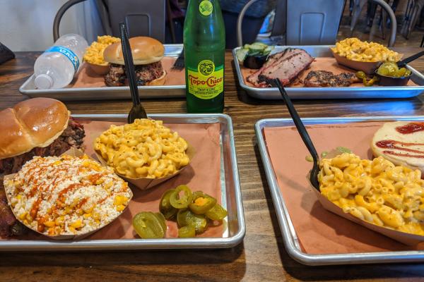 Photo of food trays at Hurtado Barbecue with sandwiches, corn and macaroni and cheese.