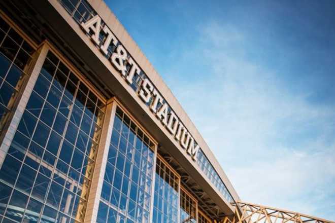 Photo of front of AT&T Stadium with sky reflection