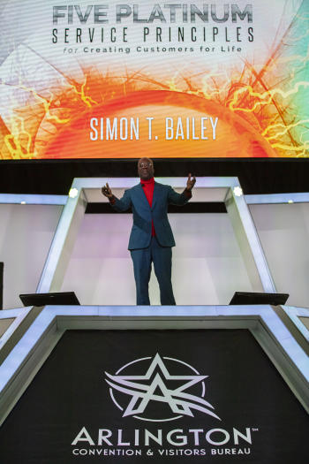 Simon T. Bailey On stage with bookcover in background
