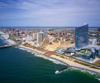 Skyline of Atlantic City, NJ with beach, resorts, Boardwalk, and the Steel Pier in view.