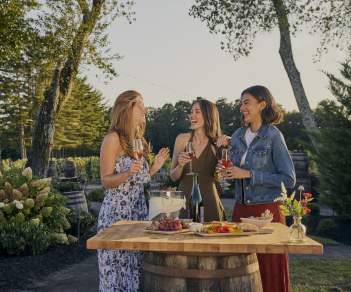 Women enjoy some wine over light bites in an outdoor setting at Renault Winery and Resort.