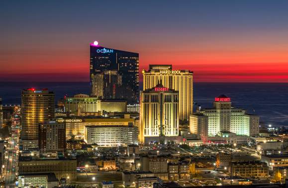 Atlantic City skyline at sunset featuring Ocean Casino Resort, Hard Rock Hotel & Casino, and beachfront resorts along the New Jersey coast
