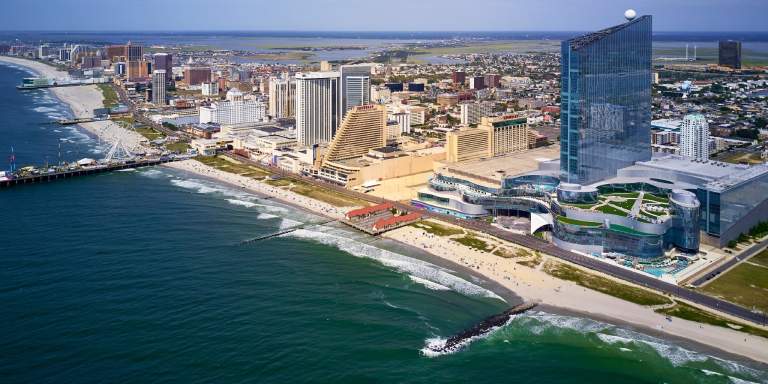 Skyline of Atlantic City, NJ with beach, resorts, Boardwalk, and the Steel Pier in view.