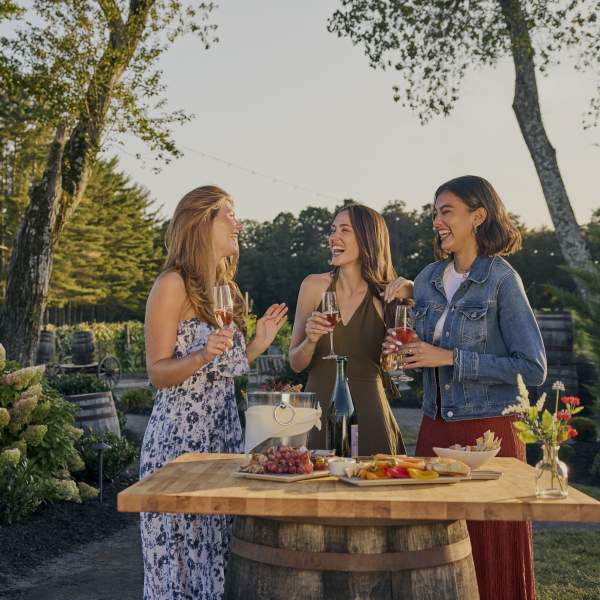Women enjoy some wine over light bites in an outdoor setting at Renault Winery and Resort.