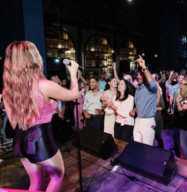 Band members perform on stage as people gather and dance to live music at Nola's Bar in Ocean Casino Resort.