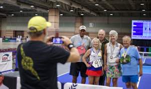 Participants pose for a photo after a USA Pickleball tournament match at an indoor pickleball event in Atlantic City, New Jersey.