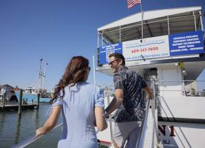 A man and woman couple boards the AC Cruisin 1 to take a boat cruise around Atlantic City coastal waters.