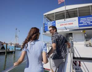 A man and woman couple boards the AC Cruisin 1 to take a boat cruise around Atlantic City coastal waters.