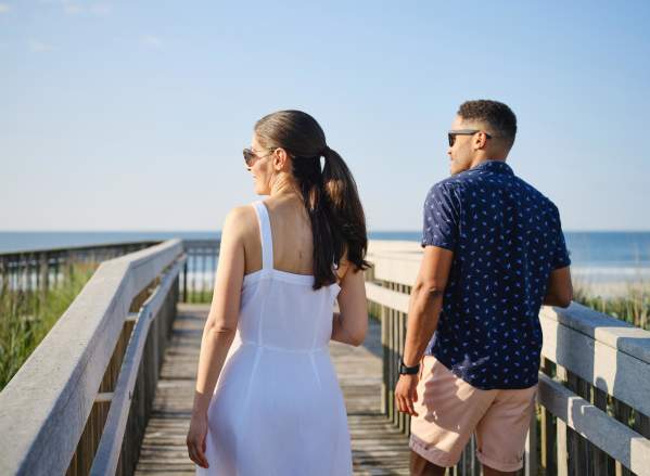 Two people walk down a beach entrance to access a beach in Atlantic City, NJ.