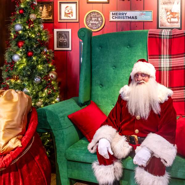 Santa's sits on an oversized green couch at Santa's Hideaway Adventure in Atlantic City.
