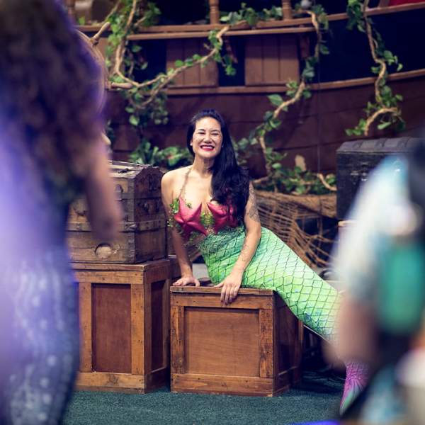 Woman in mermaid costume on undersea set at the Scuba Show.