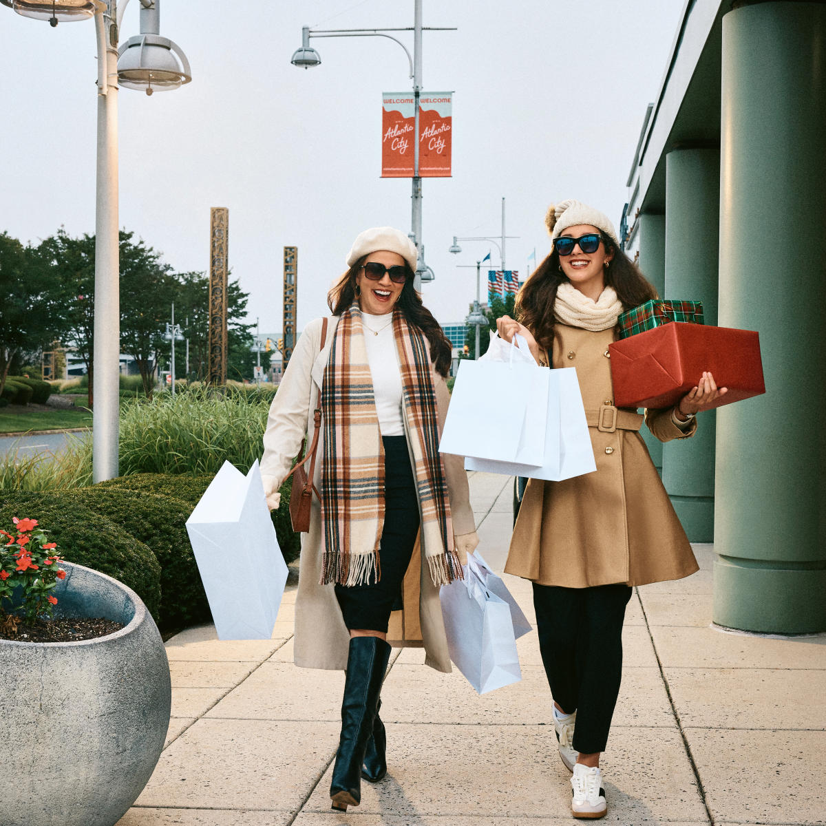 Two women with shopping bags and gifts stroll through Tanger Outlets Atlantic City. Holiday shopping.