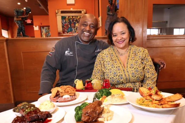 Owners of Kelsey's Restaurant in Atlantic City sit at a table displaying various home-cooked dishes.