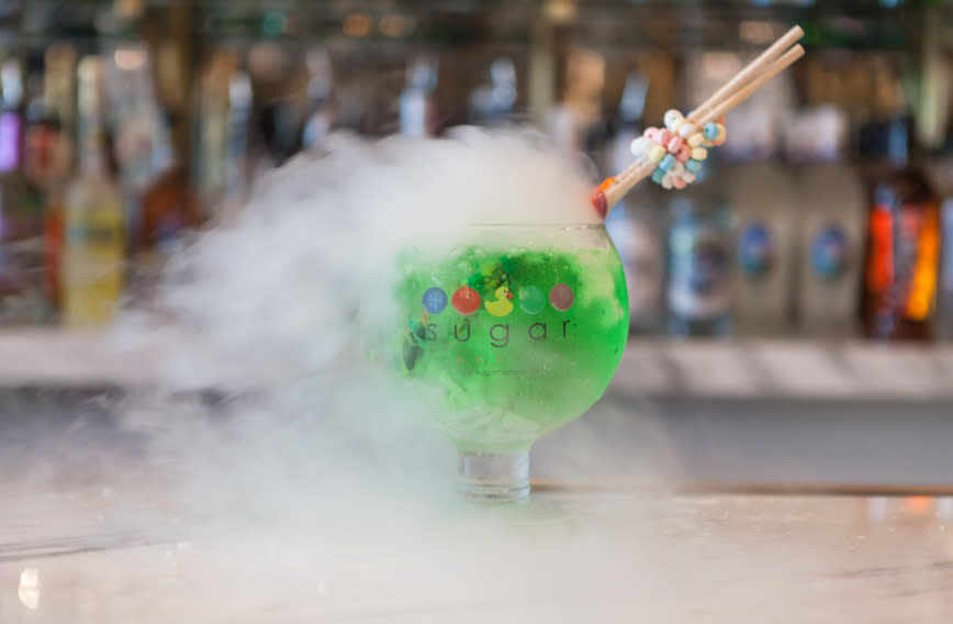 Sugar Factory Goblet with candy garnish as steam pours from the frosty green colored beverage.