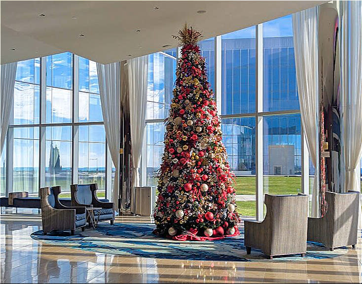 Ocean Casino Resort Tree stands tall decorated with ornate red and gold accents in a relaxing setting adorned by large windows looking towards the park.
