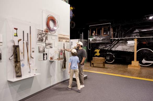 Parent and child discover Augusta's history together while exploring museum exhibits featuring historic artifacts and a restored train engine.