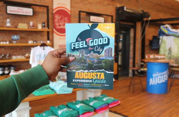 Person Holding Experience Guide at Augusta & Co.