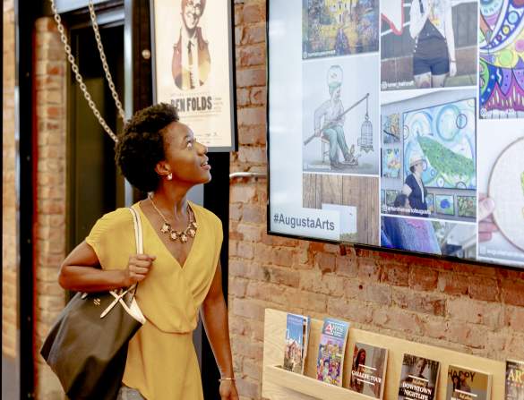 Woman Looking at TV Screen in Augusta & Co.