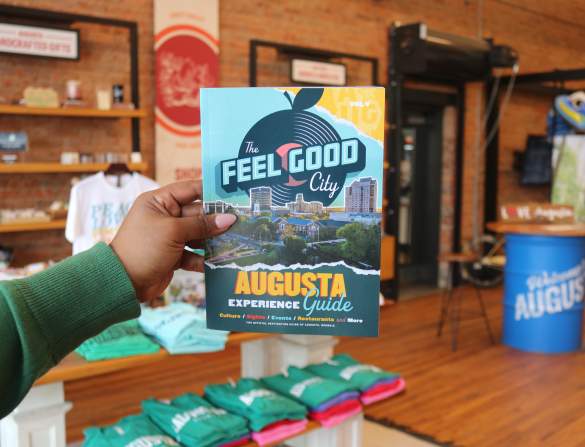 Person Holding Experience Guide at Augusta & Co.