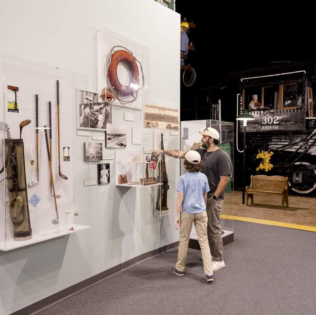 Parent and child discover Augusta's history together while exploring museum exhibits featuring historic artifacts and a restored train engine.