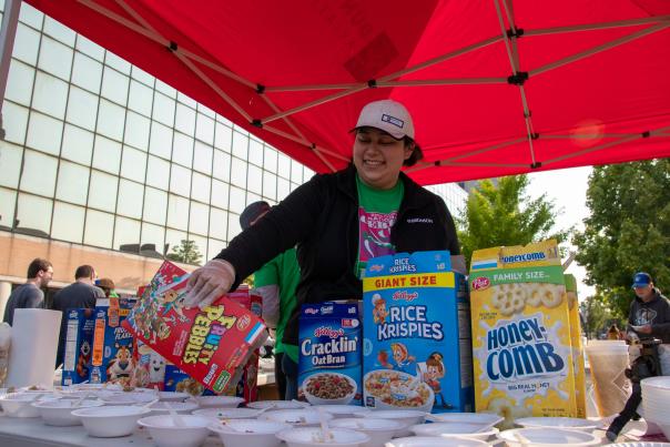 Colorful breakfast table at Battle Creek’s Cereal Festival featuring Fruity Pebbles, Rice Krispies, and ready-to-serve bowls with spoons.