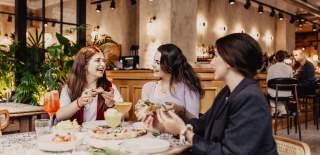 Group of girls enjoying pizza and drinks at Amelia Hall