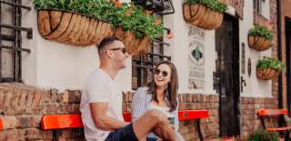 Couple enjoying coffee on bench in commercial court