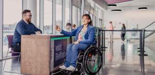 Woman talking to Visit Belfast staff in the ICC Belfast