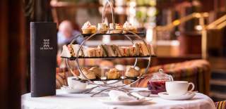 Image showcasing sandwiches, cupcakes, scones and tea as part of Europa Hotel's afternoon tea.