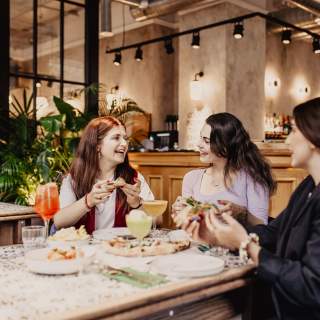 Group of girls enjoying pizza and drinks at Amelia Hall
