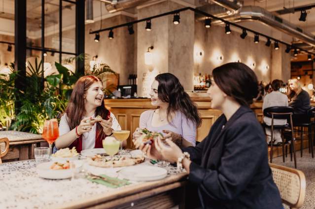 Group of girls enjoying pizza and drinks at Amelia Hall