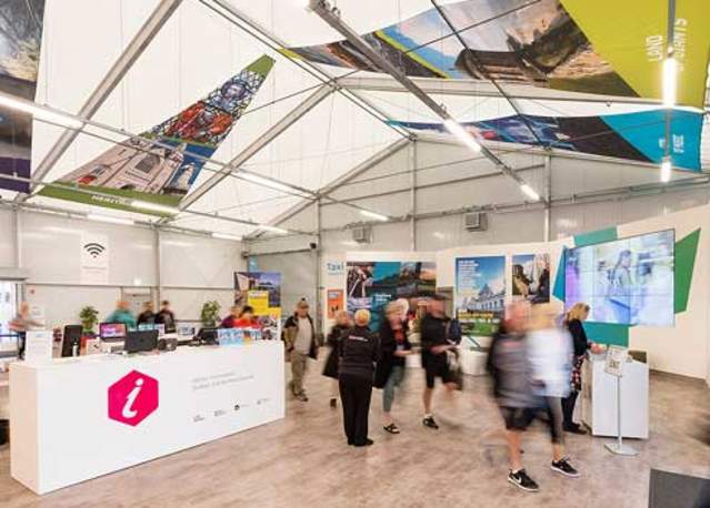 People walking to and from the Belfast Cruise information desk