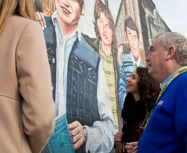 A group of girls looking at the peace walls during a value cabs taxi tour.