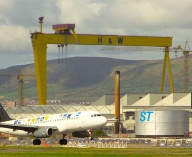 Photo of plane at belfast city airport taking off, with harland and wolff in the background.