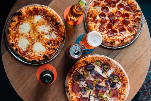 Three pizzas and drinks on a table at Pug Uglys Belfast