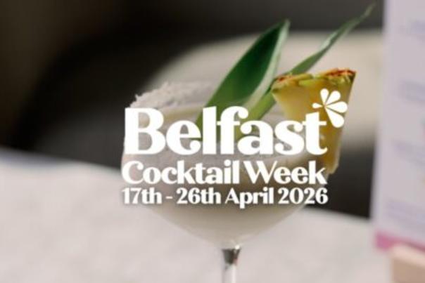 A creamy cocktail in a glass with a salted rim, garnished with pineapple and leaves. Text: "Belfast Cocktail Week, 17th-26th April 2026."