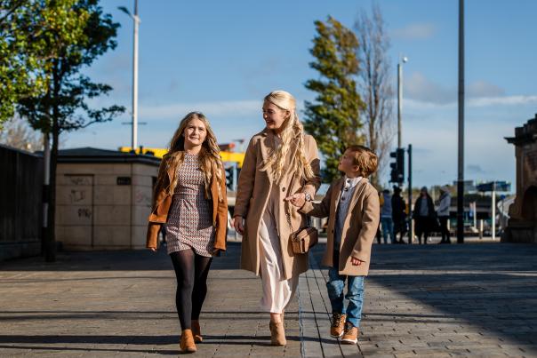 Photo of mum and two kids holding hands, walking through Belfast city centre.