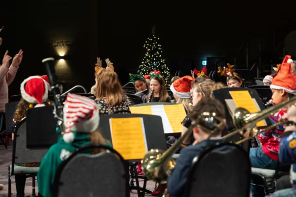 Children with santa hats on playing music in Belfast.