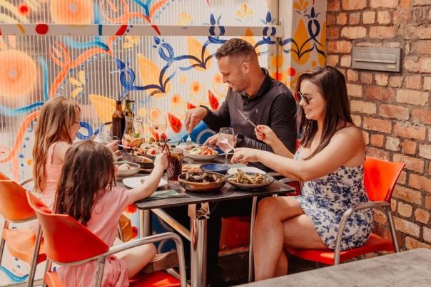 Family enjoying dinner outside at 2Taps Winebar & Restaurant.