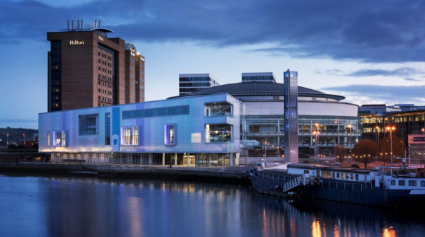 Photo of the waterfront hall in Belfast overlooking the water with the Hilton hotel in the background.