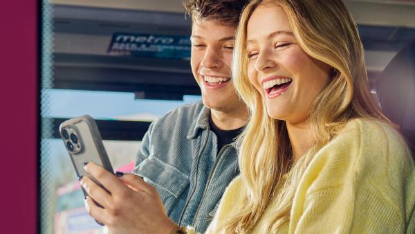 Couple on Translink Metro Bus looking at mobile phone
