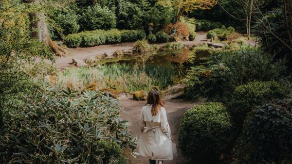 Woman walking through Lady Dixon Park at the pond