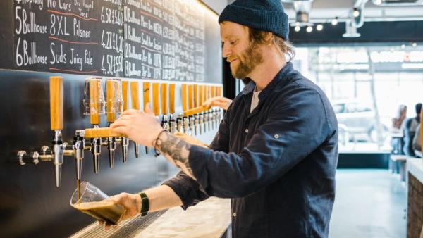 Man pouring craft beer at Bullhouse East