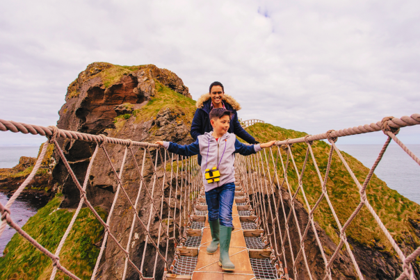 Father and son walking across Carrick-a-rede rope bridge