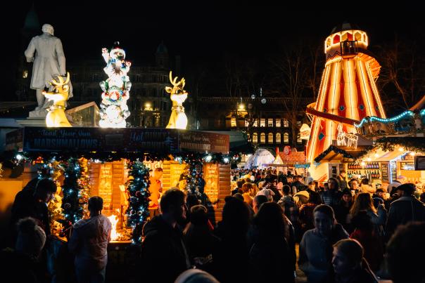 Photo of lights at Belfast Christmas markets, with stalls underneath