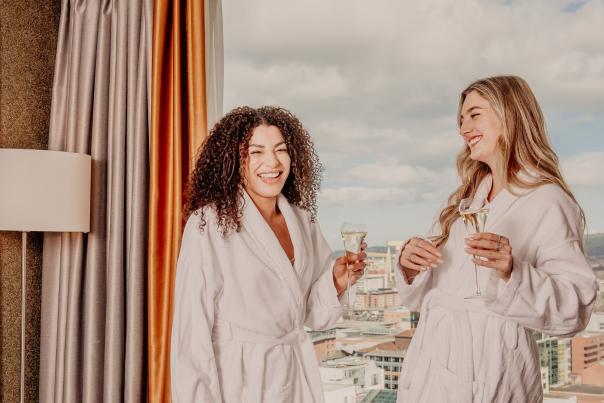 Two women in bath robes drinking champagne at the Grand Central Hotel