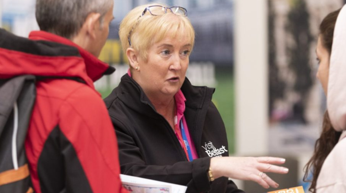 Woman talking to people at Visit Belfast Welcome Centre