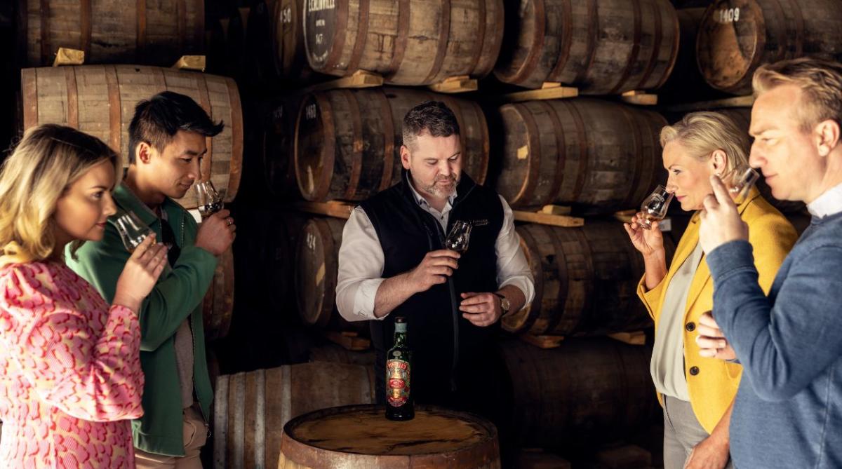 Group smelling whiskey with guide at distillery
